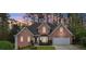 Inviting two-story red brick home featuring a well-manicured lawn, bay window, and attached two-car garage at 740 Trillium Ln, Lilburn, GA 30047