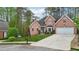 A brick home with well-kept landscaping, an attached garage, and a paved driveway at 740 Trillium Ln, Lilburn, GA 30047