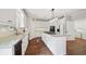 Modern kitchen with white cabinets, wood floors, granite counters, and an island with a gas cooktop at 740 Trillium Ln, Lilburn, GA 30047