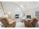 Inviting living room featuring plush reclining furniture, a fireplace, and vaulted ceilings at 740 Trillium Ln, Lilburn, GA 30047