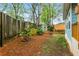 Fenced backyard with mature trees, shrubs, flowers, and grass at 1643 Wade Ne Ave, Atlanta, GA 30317