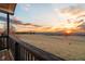 Balcony view showcasing a golden sunset, rolling hills, and pasture at 1909 Hickory Level Rd, Villa Rica, GA 30180