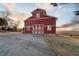 Picturesque red barn with white trim, complemented by a serene countryside backdrop at 1909 Hickory Level Rd, Villa Rica, GA 30180