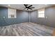 An unfinished bedroom with new floors, a ceiling fan and natural light from two windows at 1909 Hickory Level Rd, Villa Rica, GA 30180