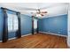 Spacious bedroom with hardwood floors, crown molding and windows with decorative curtains at 1909 Hickory Level Rd, Villa Rica, GA 30180