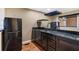 Modern kitchen with granite counters, dark wood cabinets, stainless steel appliances, and hardwood floors at 1909 Hickory Level Rd, Villa Rica, GA 30180
