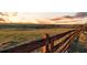 Scenic landscape view with a rustic wooden fence, rolling hills and a sunset sky at 1909 Hickory Level Rd, Villa Rica, GA 30180