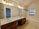 Bathroom featuring double sinks, soaking tub, and custom vanity lighting at 2930 Smith Ridge Trce, Peachtree Corners, GA 30071