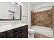 Bathroom featuring vanity, decorative mirror, toilet and a tub and shower with brown tile at 901 Abernathy Ne Rd # 3200, Atlanta, GA 30328