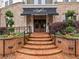 Inviting building entrance with brick steps, manicured landscaping and a black awning with white lettering at 901 Abernathy Ne Rd # 3200, Atlanta, GA 30328