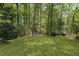 View of the home's lush green backyard and surrounding mature trees providing shade at 3100 Templeton Ln, Loganville, GA 30052