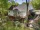 Home's backyard features a large wooden deck, patio, and mature landscaping at 3100 Templeton Ln, Loganville, GA 30052