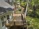 Back deck featuring wood planks, outdoor stairs, and lush landscaping at 3100 Templeton Ln, Loganville, GA 30052