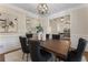 Bright dining area with a dark wood table and six upholstered chairs beneath a modern light fixture at 3100 Templeton Ln, Loganville, GA 30052