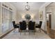 Formal dining room featuring a modern chandelier, large windows, and stylish black chairs at 3100 Templeton Ln, Loganville, GA 30052