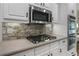 Close-up of kitchen featuring stainless steel appliances and stone backsplash at 3100 Templeton Ln, Loganville, GA 30052