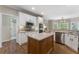 Kitchen with island, stainless steel appliances, stone backsplash, and hardwood floors at 3100 Templeton Ln, Loganville, GA 30052