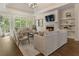 Spacious living room with a fireplace, large windows, tray ceilings, and hardwood floors at 3100 Templeton Ln, Loganville, GA 30052