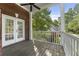 Covered brick porch with ceiling fan, wooden deck, and white railing at 3100 Templeton Ln, Loganville, GA 30052