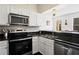 Well-lit kitchen featuring stainless steel appliances, dark countertops, and white cabinets at 2855 Peachtree Ne Rd # 115, Atlanta, GA 30305