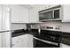 Kitchen featuring stainless steel appliances, white cabinets, and dark countertops at 2855 Peachtree Ne Rd # 115, Atlanta, GA 30305