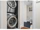 Modern stacked washer and dryer with a partial view into the bathroom, combining practicality with space-saving design at 2855 Peachtree Ne Rd # 115, Atlanta, GA 30305