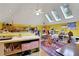 Bright art studio featuring multiple skylights, yellow walls, an easel, and storage, perfect for creative pursuits at 3835 Paces Ferry Nw Rd, Atlanta, GA 30327