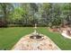 Picturesque backyard featuring a manicured lawn, mature trees, and an elegant stone fountain at 3835 Paces Ferry Nw Rd, Atlanta, GA 30327