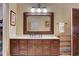 Elegant bathroom featuring dark wood cabinets, marble countertop, and decorative mirror at 3835 Paces Ferry Nw Rd, Atlanta, GA 30327