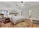 Bright bedroom with hardwood floors, white linens, ceiling fan, and a seating area at 3835 Paces Ferry Nw Rd, Atlanta, GA 30327