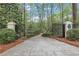Gated driveway entrance leading to a private estate surrounded by mature trees and manicured landscaping at 3835 Paces Ferry Nw Rd, Atlanta, GA 30327