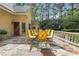 View of patio with iron furniture, stone flooring, and elegant balustrade with a view of the tree-lined yard at 3835 Paces Ferry Nw Rd, Atlanta, GA 30327