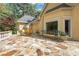 Wide stone patio with wrought-iron furniture offering scenic views of the surrounding yard and mature trees at 3835 Paces Ferry Nw Rd, Atlanta, GA 30327