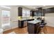 Modern kitchen with dark cabinets, stainless steel appliances, granite countertops, and a convenient island with bar stools at 5016 Whiteoak Se Pointe, Smyrna, GA 30080