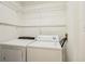 Washer and dryer room with wire shelving for ample storage solutions at 5638 River Heights Se Xing, Marietta, GA 30067