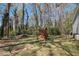Expansive backyard featuring mature trees, a play set, and ample space for outdoor activities at 90 Chimney Rise Ct, Stockbridge, GA 30281