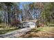 Single-story home with two-car garage, a well-kept lawn, a long driveway, and a wooded backdrop at 90 Chimney Rise Ct, Stockbridge, GA 30281
