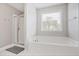 Bathroom with a tub, a glass enclosed shower, a window with blinds, and neutral paint at 350 Marble Springs Rd, Lilburn, GA 30047