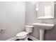 Bathroom with tile floors, a pedestal sink, a white toilet, and a large mirror at 350 Marble Springs Rd, Lilburn, GA 30047