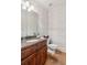 This stylish powder room features floral wallpaper, a wood vanity, and a classic toilet at 968 Woodtrace Ln, Auburn, GA 30011