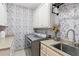 The laundry room showcases a modern washer and dryer, elegant wallpaper, and a sink for added convenience at 968 Woodtrace Ln, Auburn, GA 30011