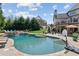 A backyard oasis featuring a pool, a sitting area with a fire pit, and a well-maintained patio at 968 Woodtrace Ln, Auburn, GA 30011