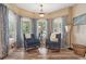 Cozy sitting room with large windows, blue rocking chairs, and light colored walls at 968 Woodtrace Ln, Auburn, GA 30011