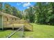 Angled view of a new backyard deck and home's yard and surrounding trees under a blue sky at 10 Powder Dr, Dallas, GA 30157