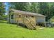 View of the backyard of a home showcasing a new deck, well maintained lawn, and ample shade trees at 10 Powder Dr, Dallas, GA 30157