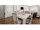 A dining room has a wooden table with chairs. Door and living room are visible at 209 Phillips Ln, Alpharetta, GA 30009