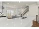 Open kitchen with a large island, stainless steel appliances, bright cabinets, and views of the staircase at 209 Phillips Ln, Alpharetta, GA 30009