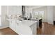 Contemporary kitchen with white cabinets, a gray backsplash, peninsula, and hardwood floors at 209 Phillips Ln, Alpharetta, GA 30009