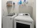 Functional laundry room with modern washer and dryer and wire shelving for storage at 209 Phillips Ln, Alpharetta, GA 30009