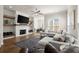 Inviting living room with a brick fireplace, floating shelves, hardwood floors, and ample seating at 209 Phillips Ln, Alpharetta, GA 30009